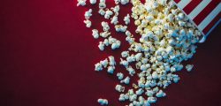 Spilled,Popcorn,On,A,Red,Background,,Cinema,,Movies,And,Entertainment